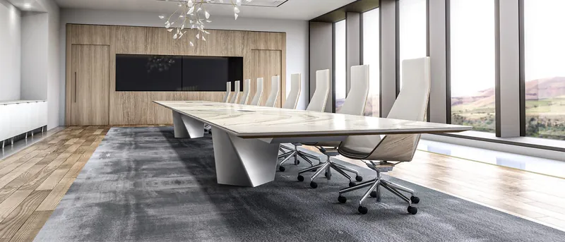 Boardroom with a long stone-look table on sculpted white bases and white high-back chairs, manufacturer photo