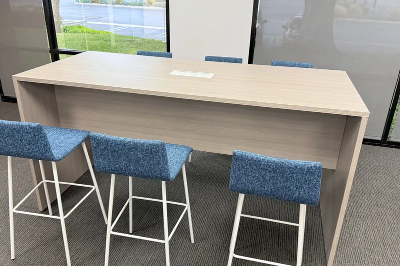 Cafe high-top table with blue stools, advisory firm office
