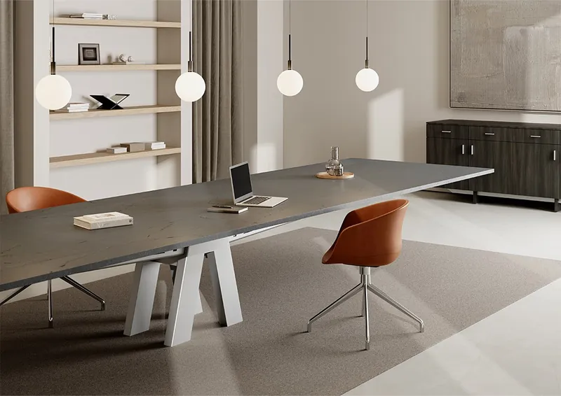 Conference room with a dark stone-look table on white angled bases and cognac swivel chairs, manufacturer photo