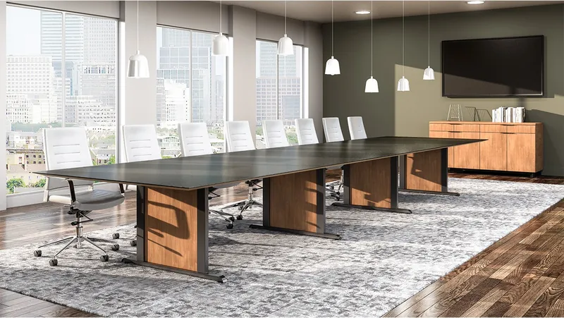 Conference room with a long dark-top table on wood-tone panel bases and white high-back chairs, manufacturer photo