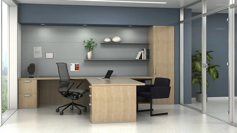 Private office with a light wood-tone U-shaped desk, open wall shelves and a tall storage tower, manufacturer photo